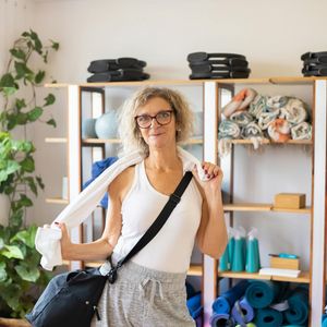 A water bottle and a towel resting on a yoga mat.